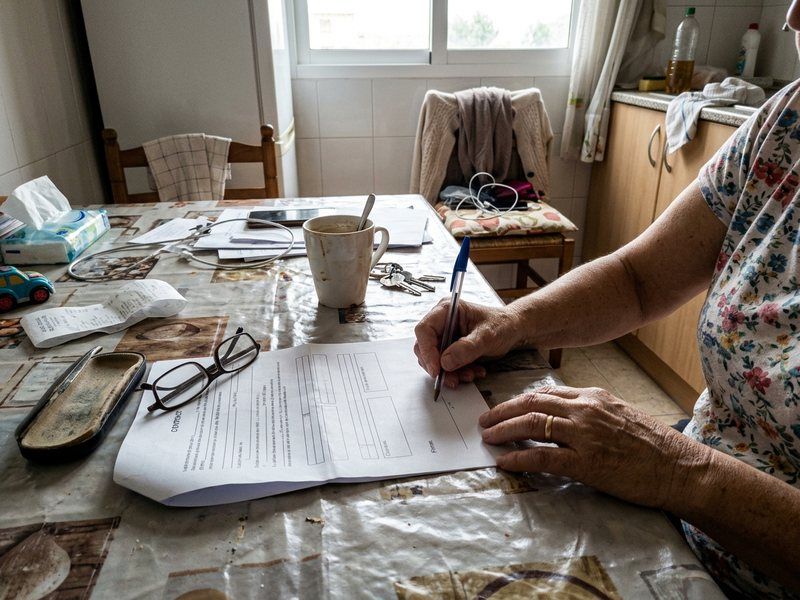 Persona firmando un contrato en la mesa
